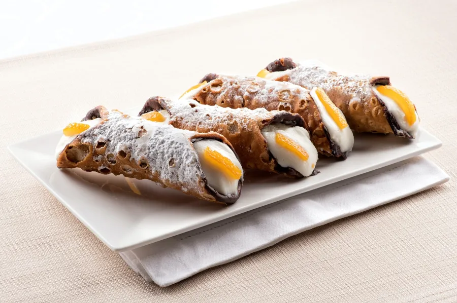 Qual è la ricetta per dei cannoli siciliani con ricotta e gocce di cioccolato?